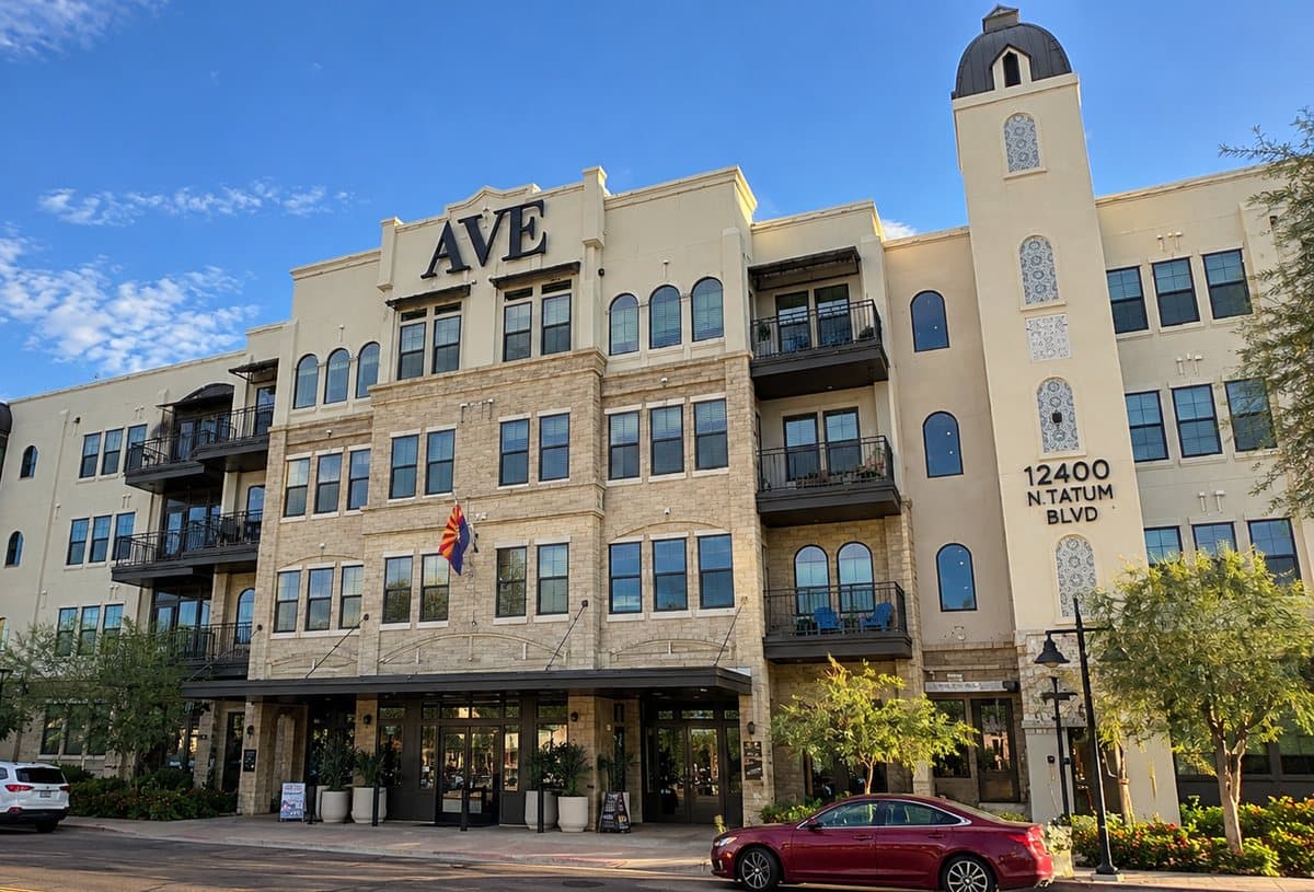 Four-story apartment building with stone and stucco facade and a corner tower on Tatum Boulevard